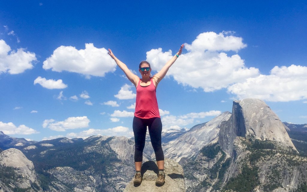 a woman stading at Glacier Point in Yosemite n