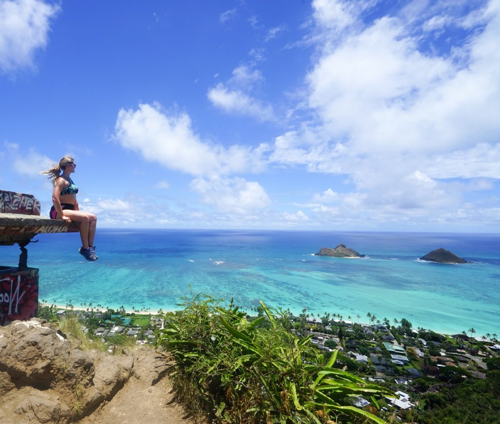 a photo of a woman sitting on a pillbox looking over the ocean