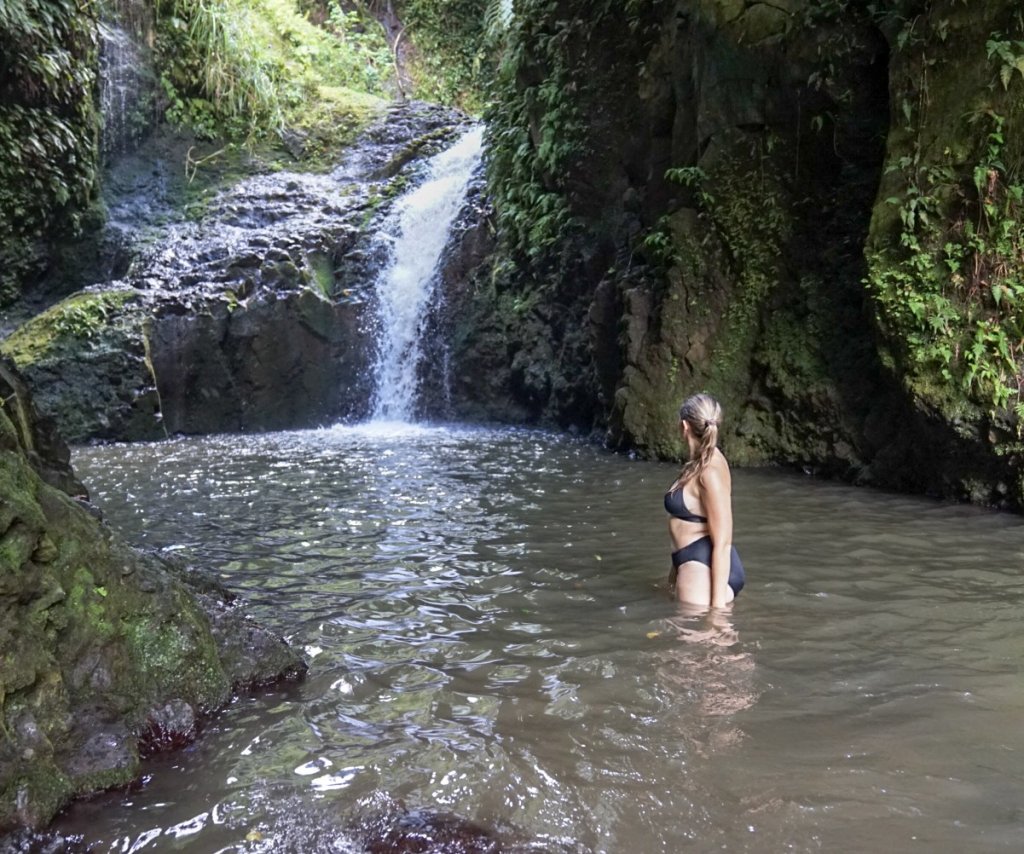 a women standing and looking at a waterall