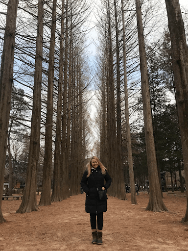 a women standing next to trees 