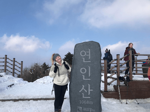 a women standing next to a stone