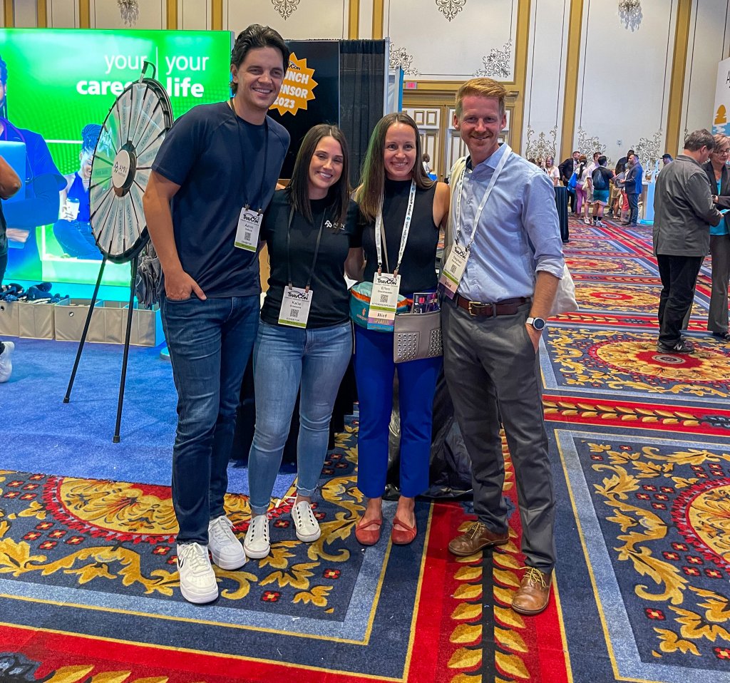 4 people standing at TravCon conference