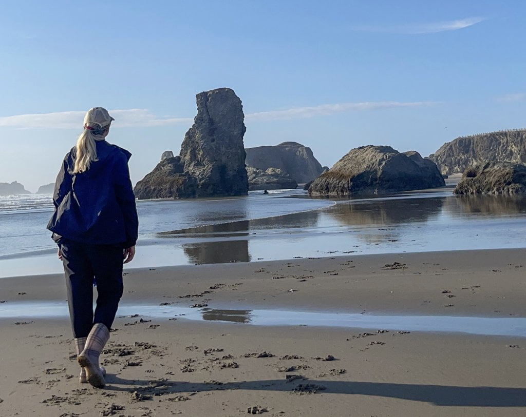 a women walking on a rocky beach