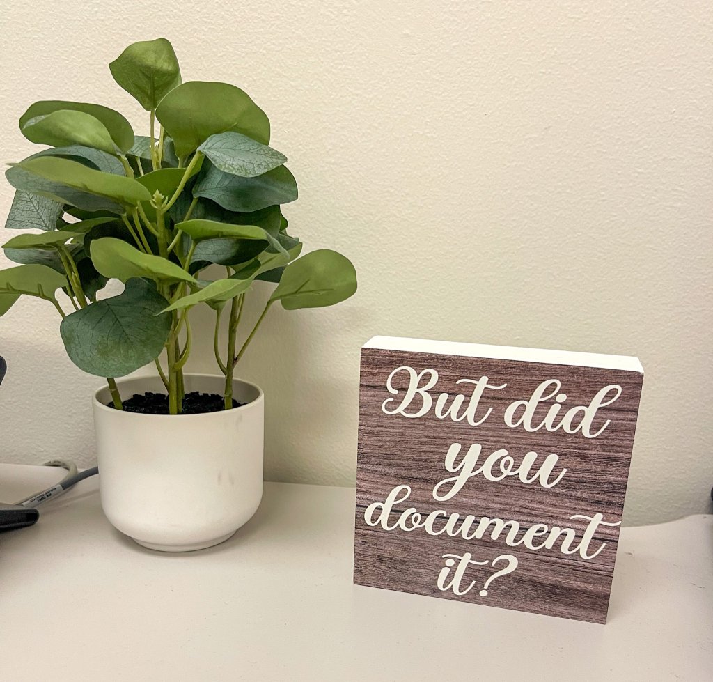 a plant and a sign that says