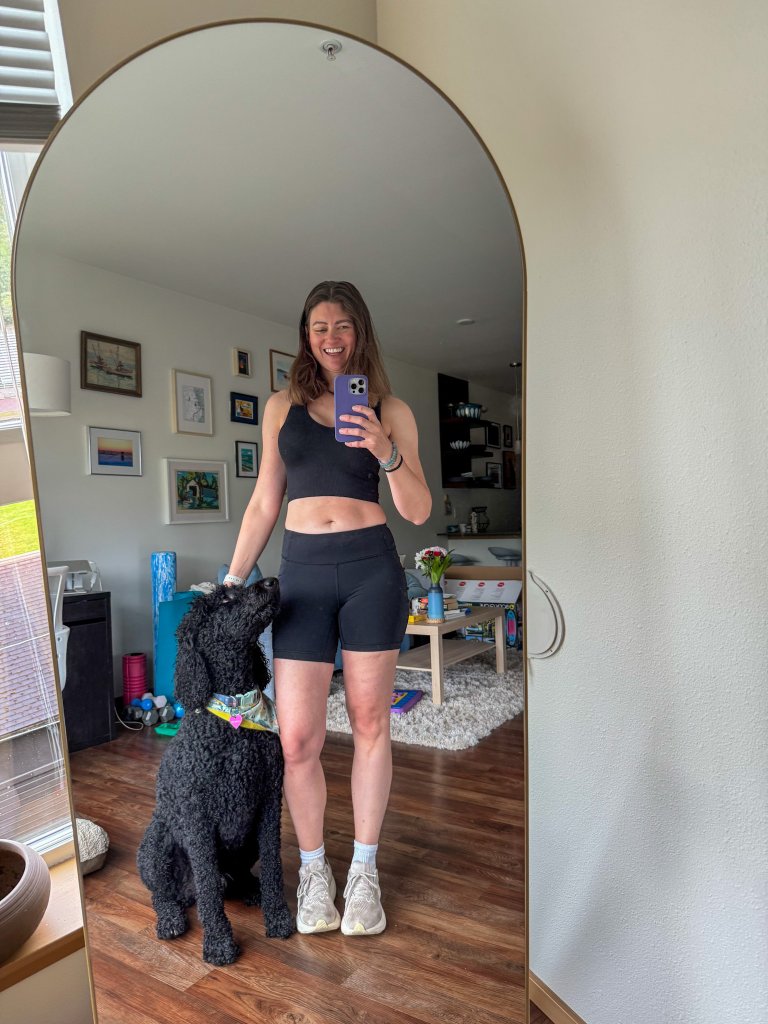 a women taking a selfie in the mirror with her dog