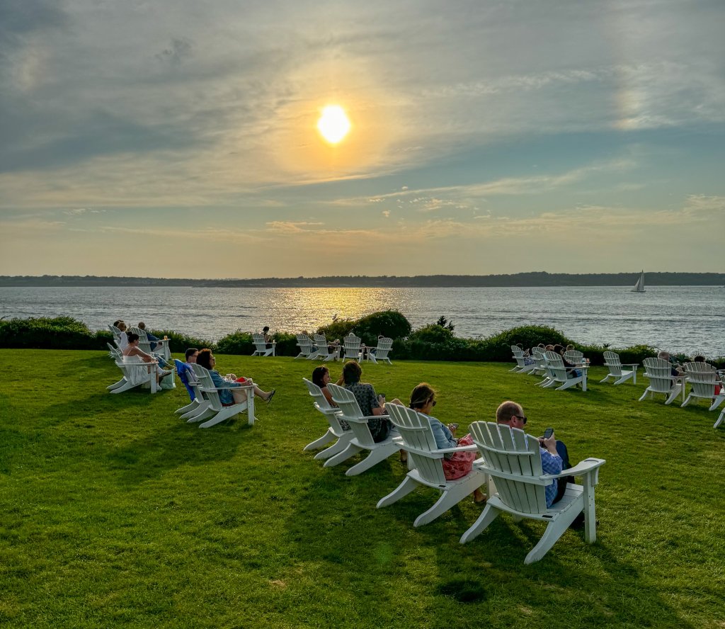 the sun setting over chairs on a lawn in newport, RI