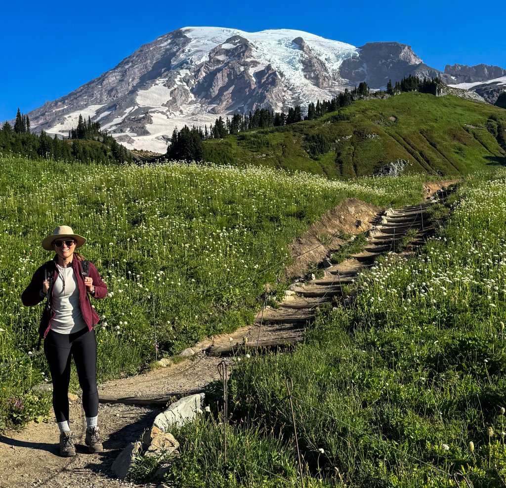 a woman standing next to a mountain
