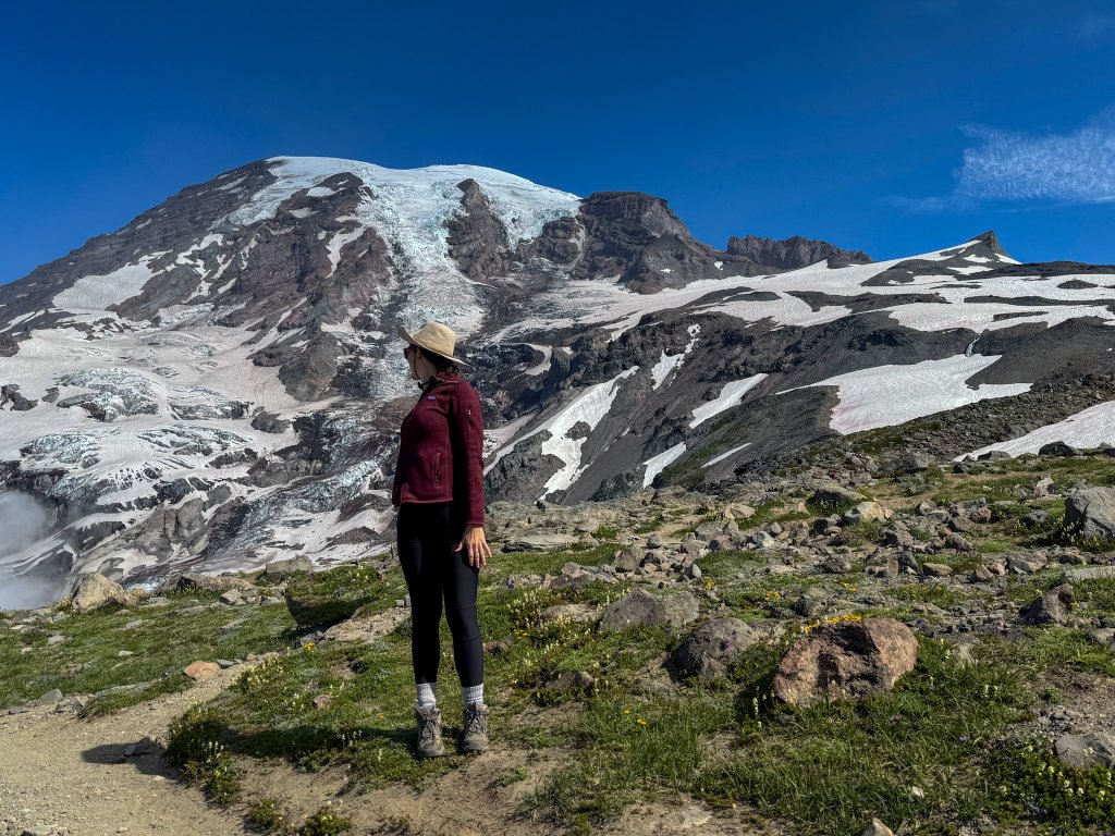 a woman standing next to a mountain