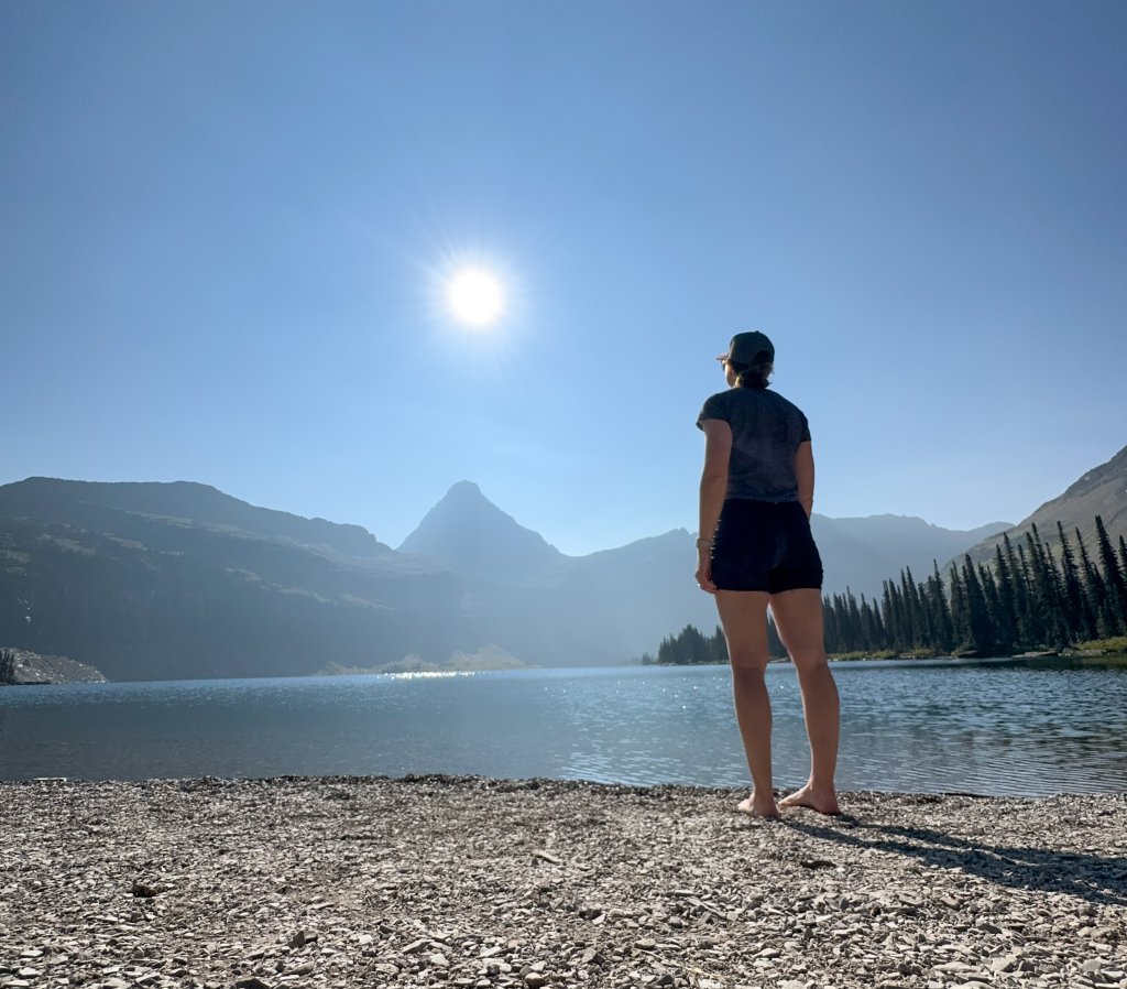 a woman standing next to a lake