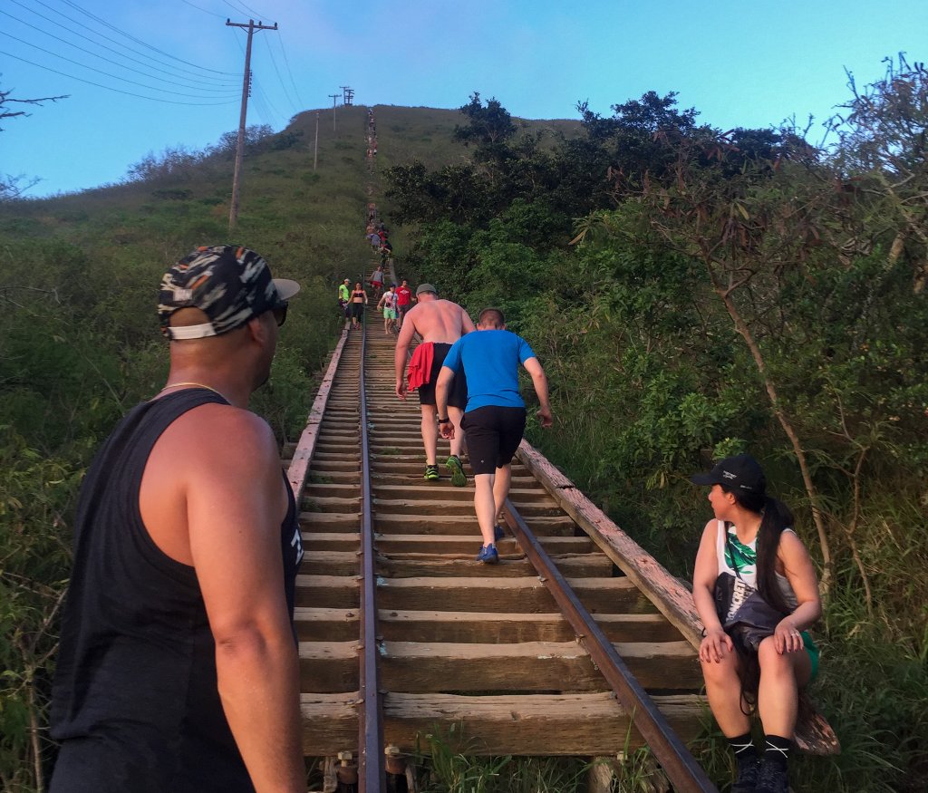 people walking railroad ties up a mountain