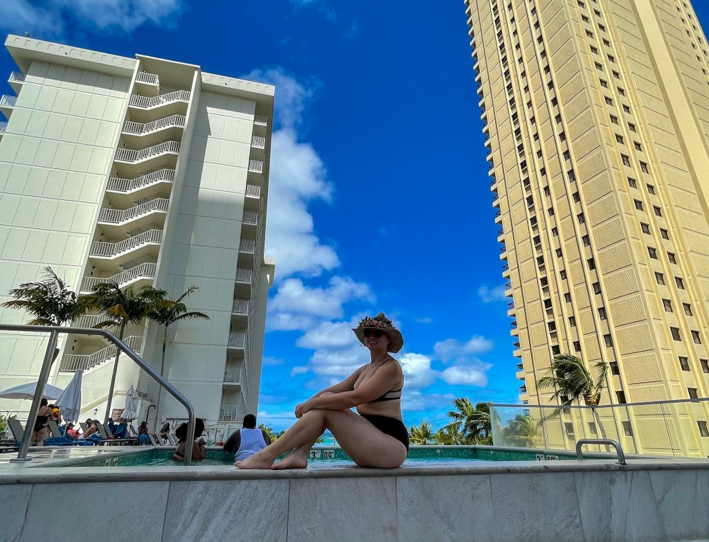 a woman sitting on a pool ledge