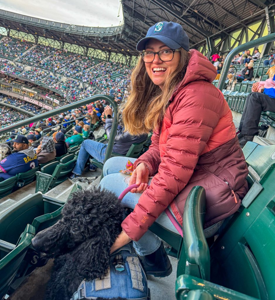 a woman and a dog at a baseball game