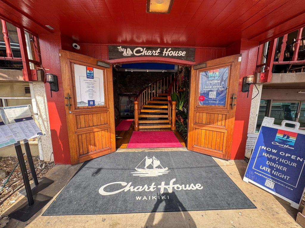 a door with a big sign that says "chart house waikiki"