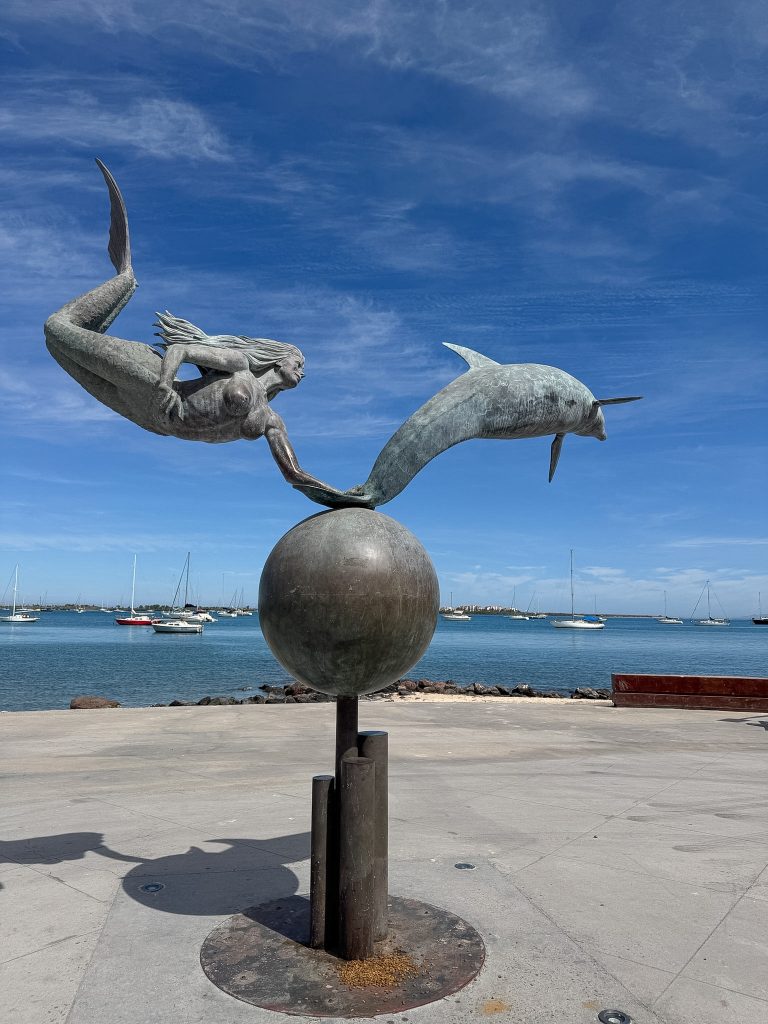 a sculpture of a mermaid and dolphin